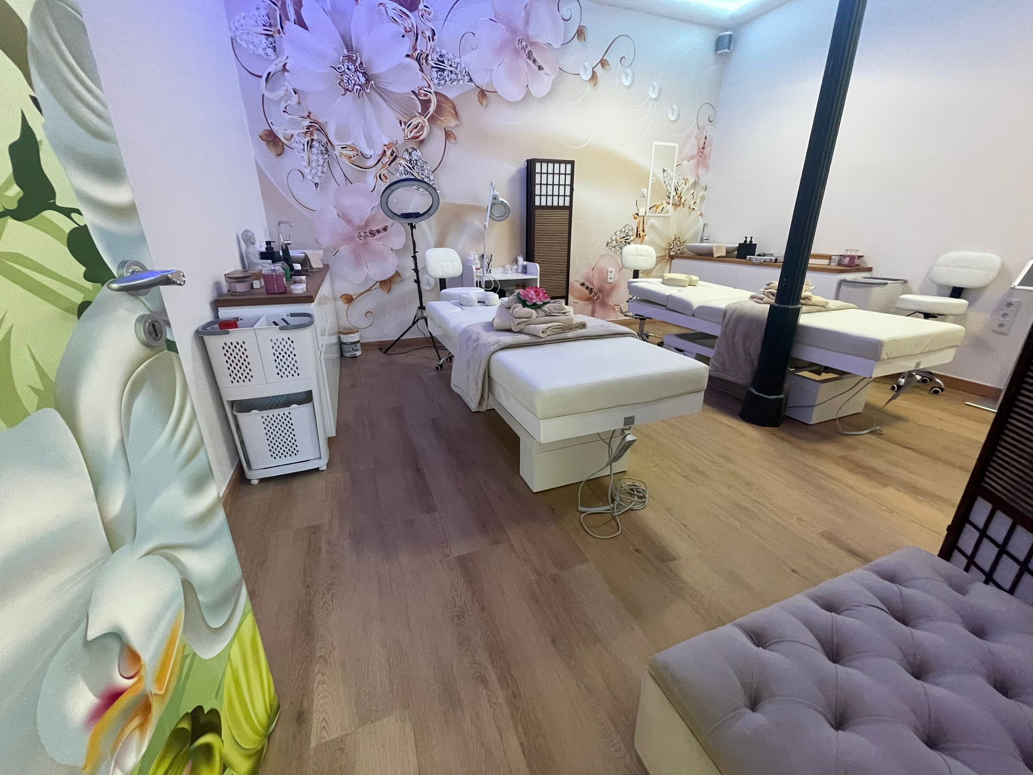 Kosmetik-Behandlungsbereich mit floralem Wandbild im ABINI Studio